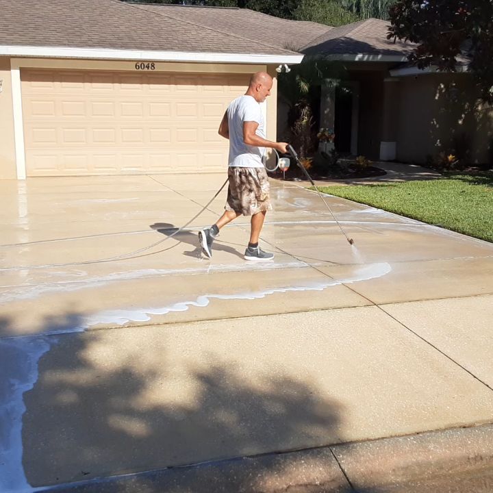 Owner-operator pressure washing a driveway